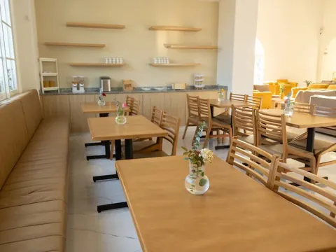 Cafetería con mesas de madera para las familias durante el velorio